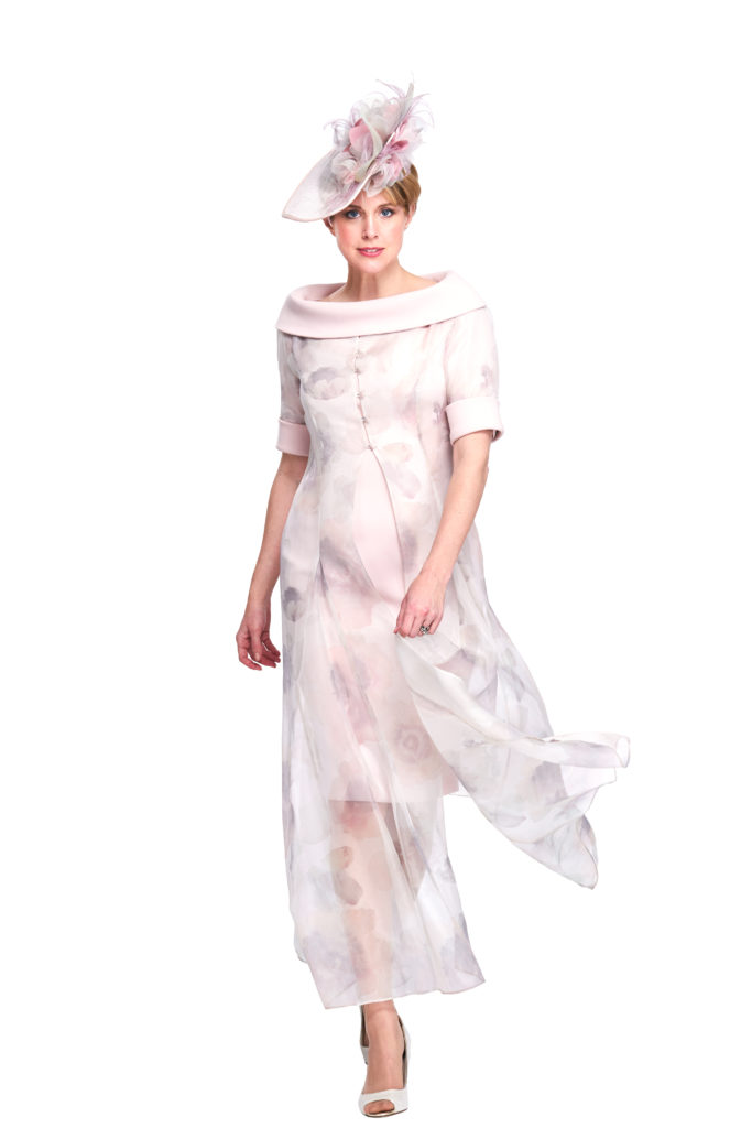 This elegant bardot neckline dress finishing at the knee, worn with the sheer ankle length coat is a perfect pairing. The full length coat creates drama and movement, but is lightweight and sheer making it easy to wear all day. The tonal floral print on the luxurious organza matches to the colour of the dress, softening the overall look.