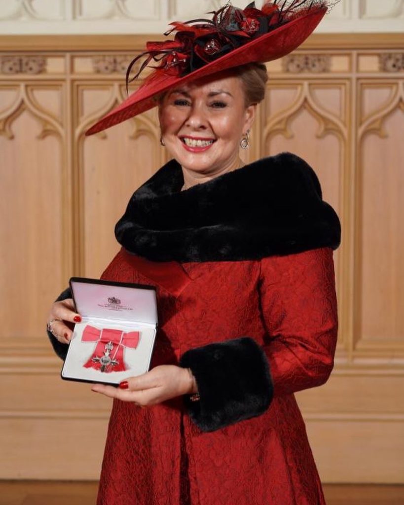 Sally Preston holds MBE medal at Windsor Palace