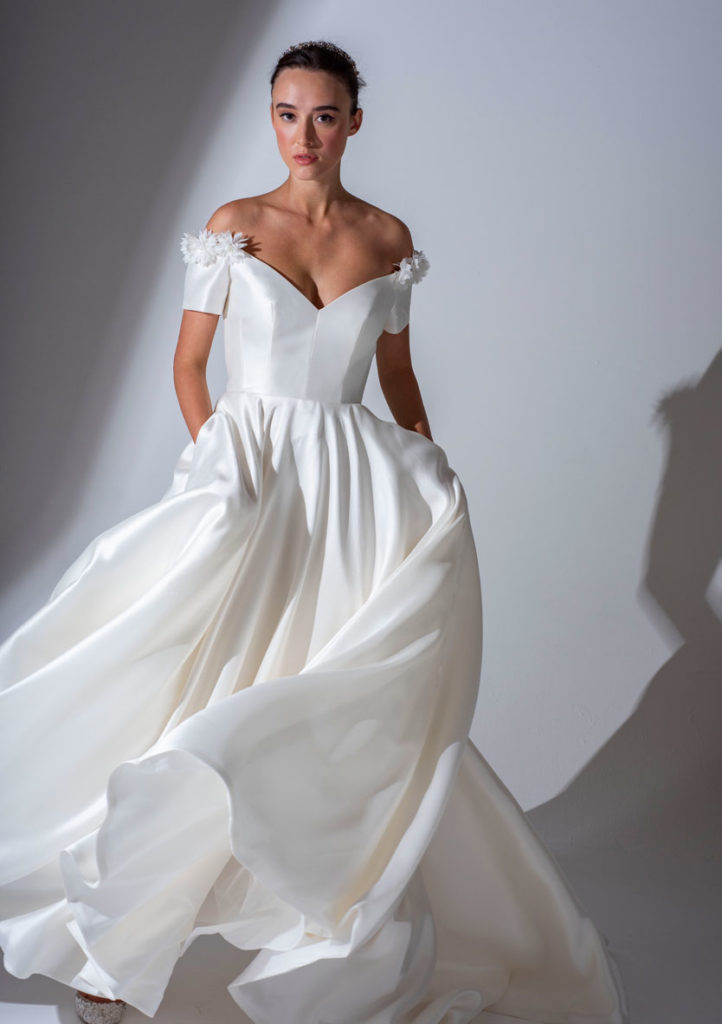 Introducing Freda Bennet Wedding DressesIvory wedding dress with flower detail on the dropped shoulder and short sleeve