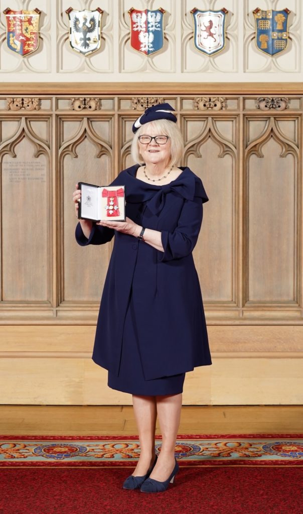 Lady holds up CBE award at Windsor Castle