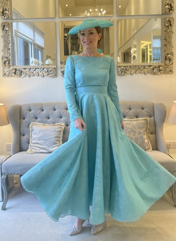 model wearing turquoise fifties style dress