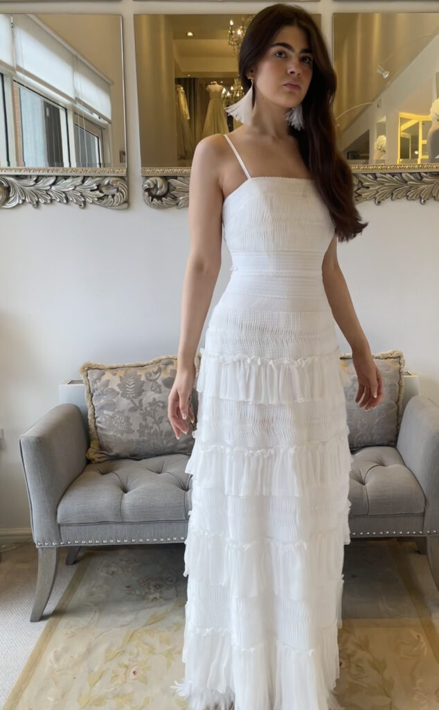Bride standing in layed boho dress with feathered hem