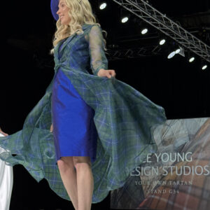 Model on catwalk wearing tartan organza coat over oyal silk dress