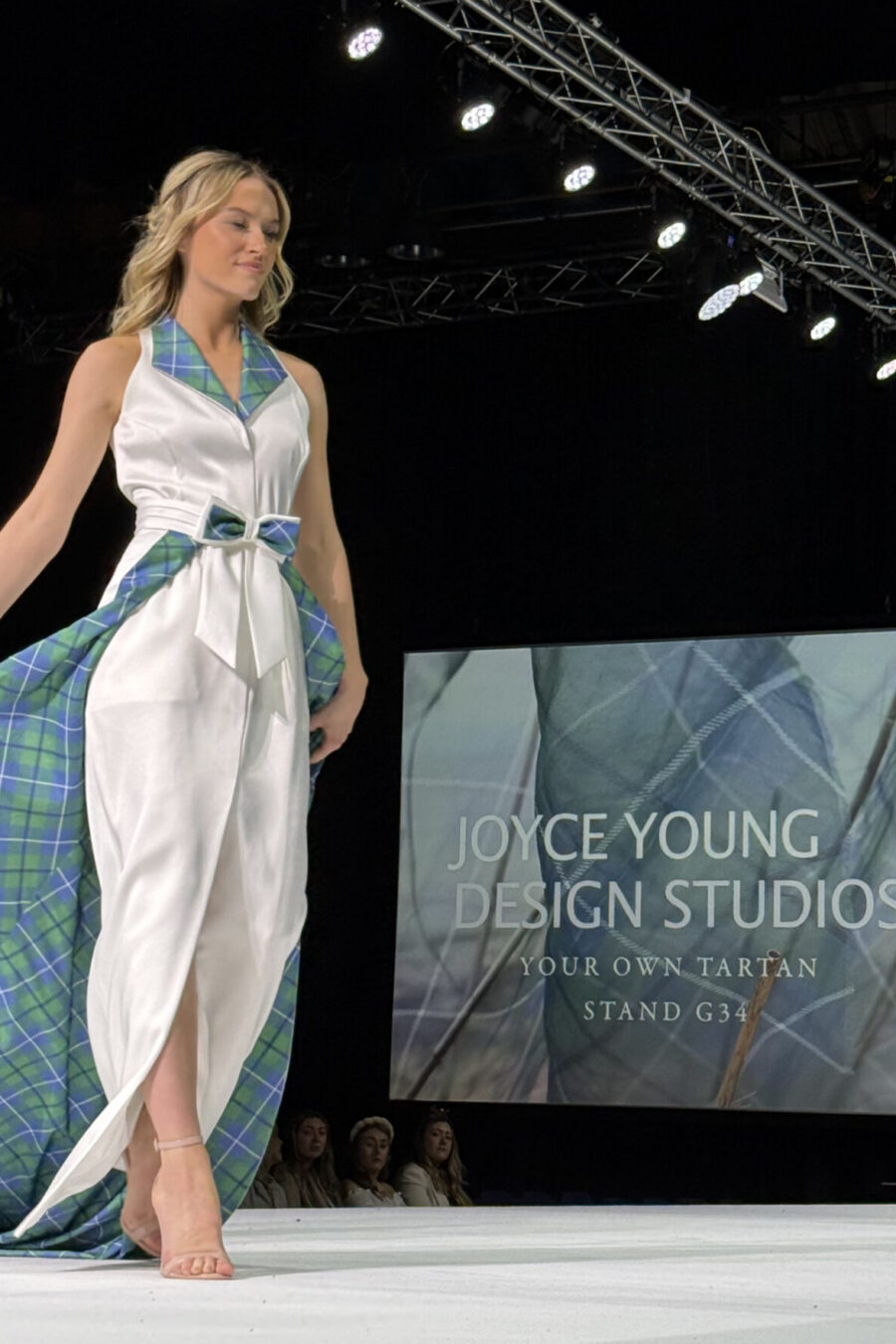 Model wearing contemporary wedding dress with tartan collar and detachable tartan lined detachable train
