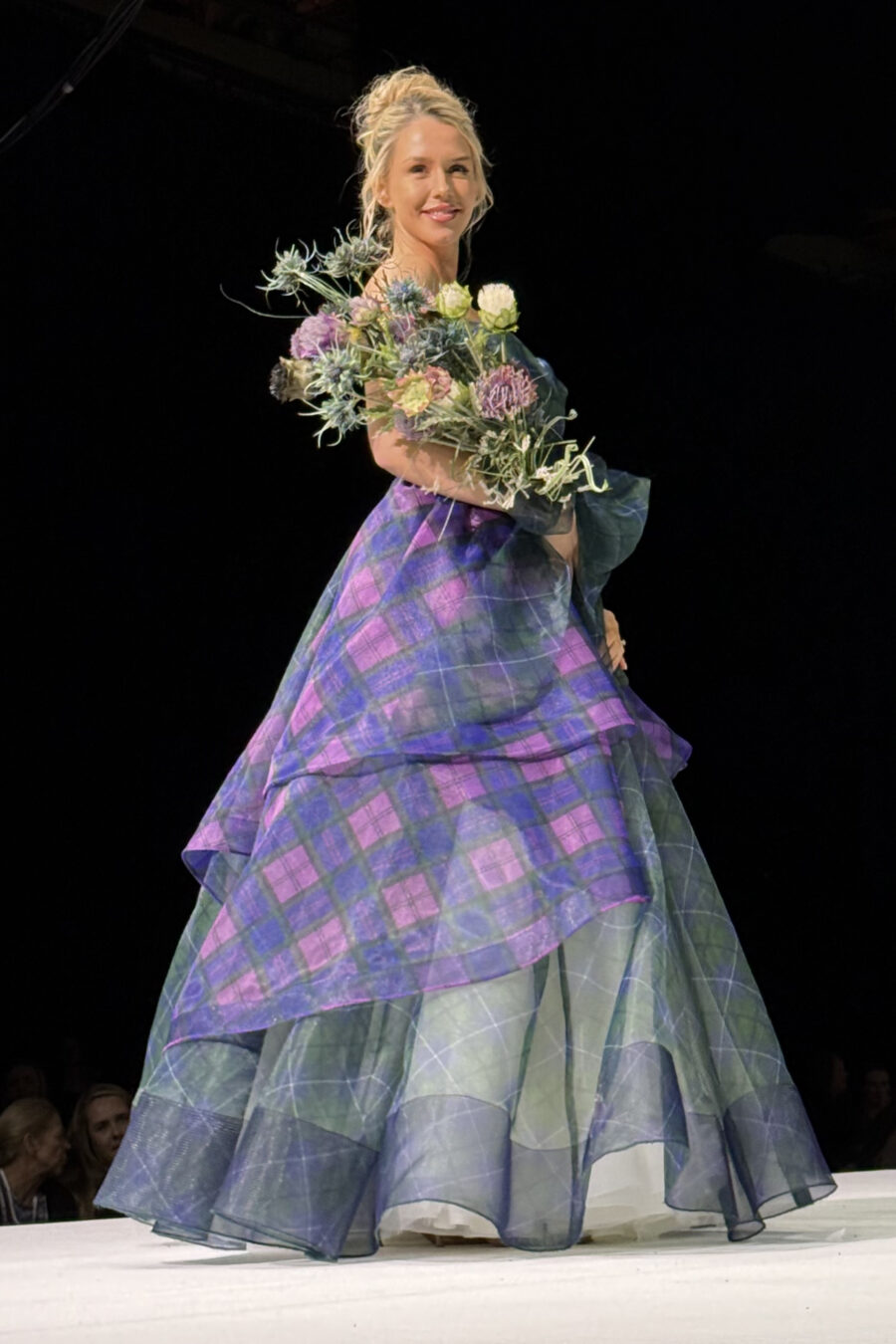 model posing on catwalk in tartan organza balgown