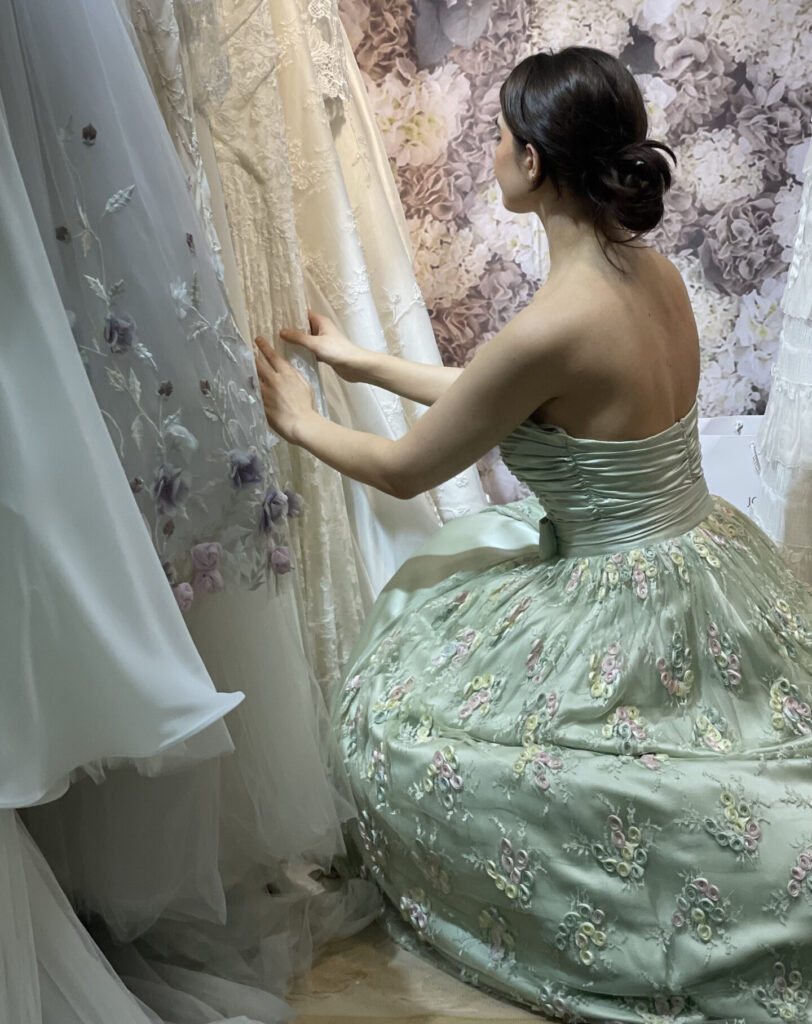 model kneeling down in green silk dress